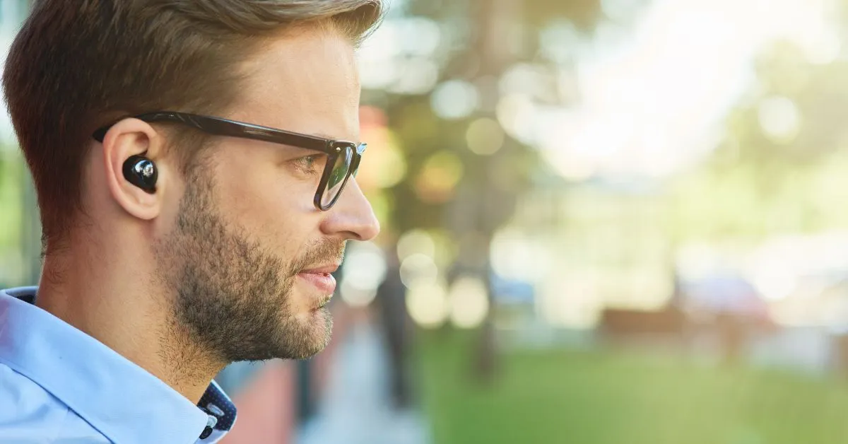 Handsome man wearing noise-cancelling earbuds